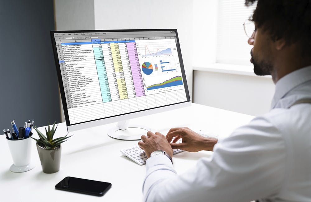 man types on keyboard to edit Excel chart