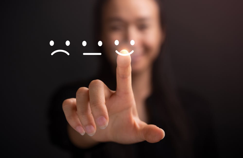 image of business women pressing smiley face touch screen indicating how good ux is key to IT moderniztion
