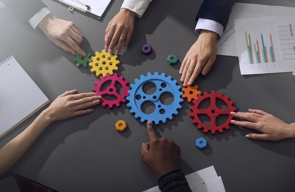 Business team connect pieces of gears. Teamwork, partnership and integration concept