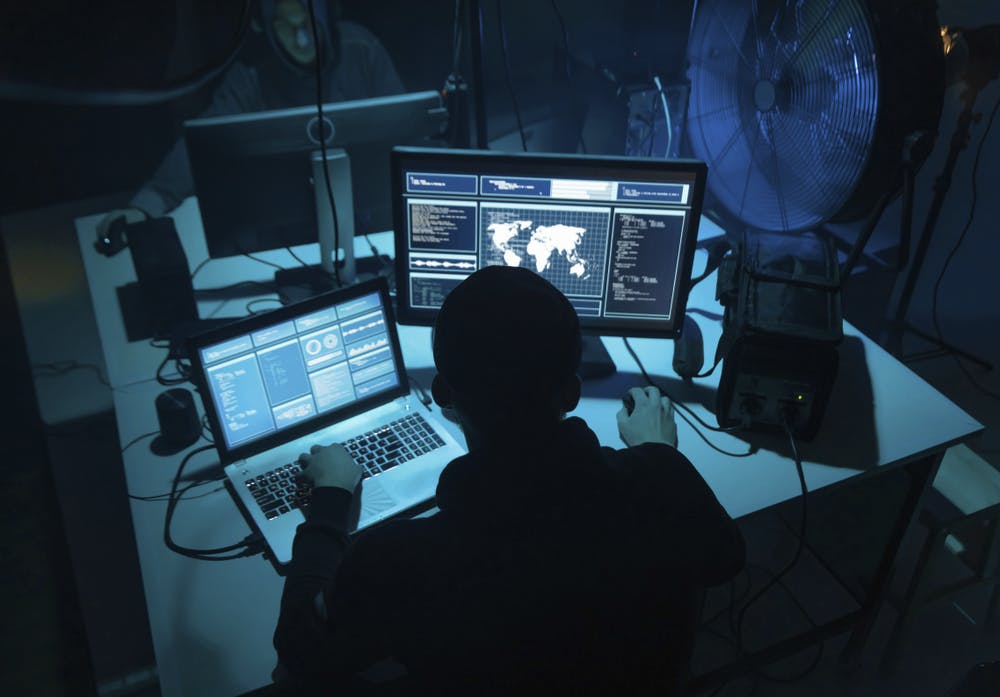 Man looks at two computer screens