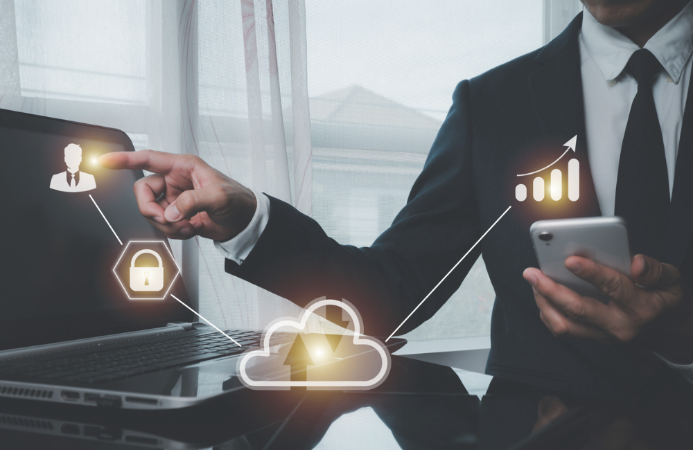 A man in a suit points the index finger of his right hand at a human symbol. Linked with the lock symbol, cloud computing, cell phone and stock graph, blurry cityscape background.