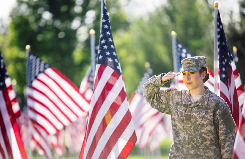 young female soldier saluting American flag