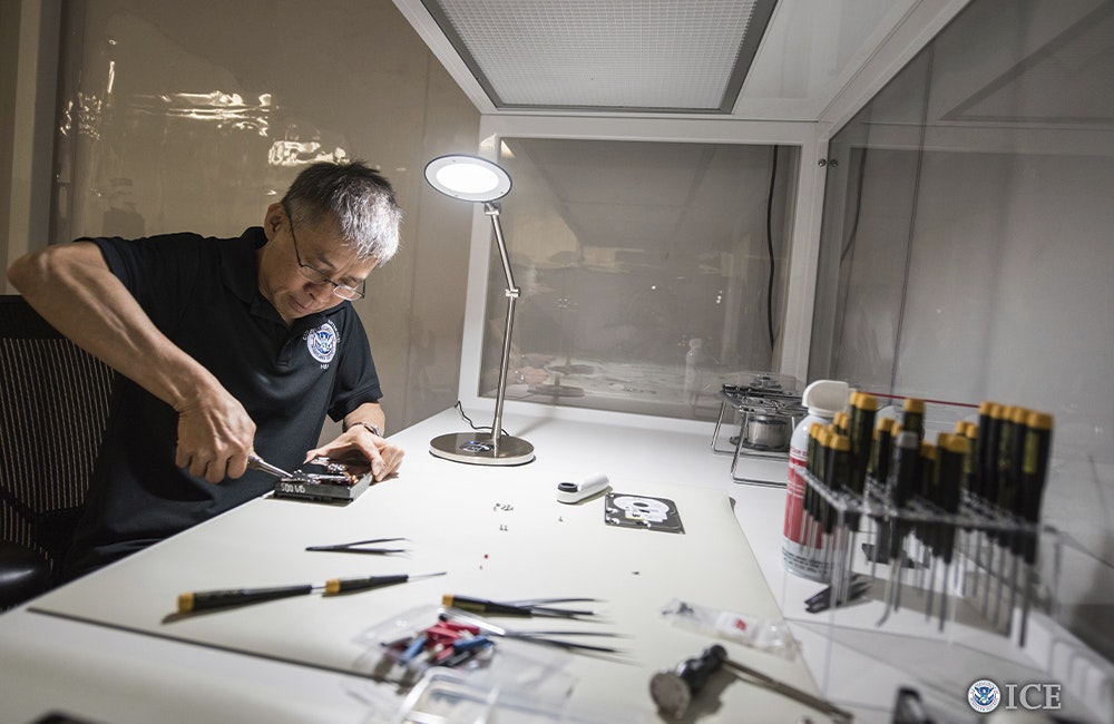 An ICE Cyber Crimes specialist takes apart a confiscated hard drive.