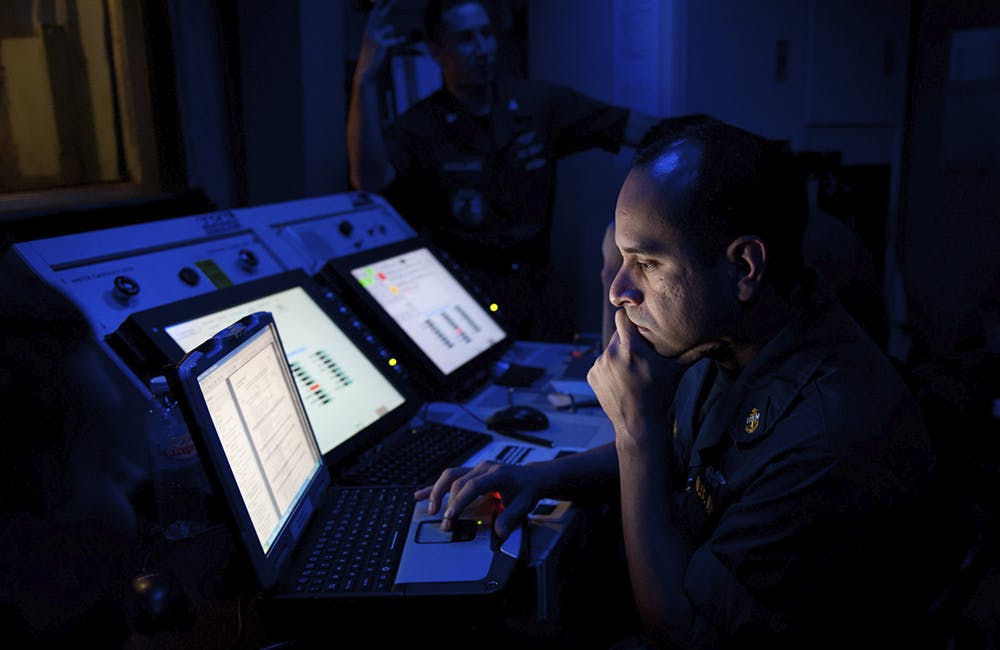 image of Chief Aviation Machinist's Mate Eddie Casusol, from New York, reviews test data from an F/A-18 engine test in the jet shop aboard the Nimitz-class aircraft carrier USS John C. Stennis (CVN 74).