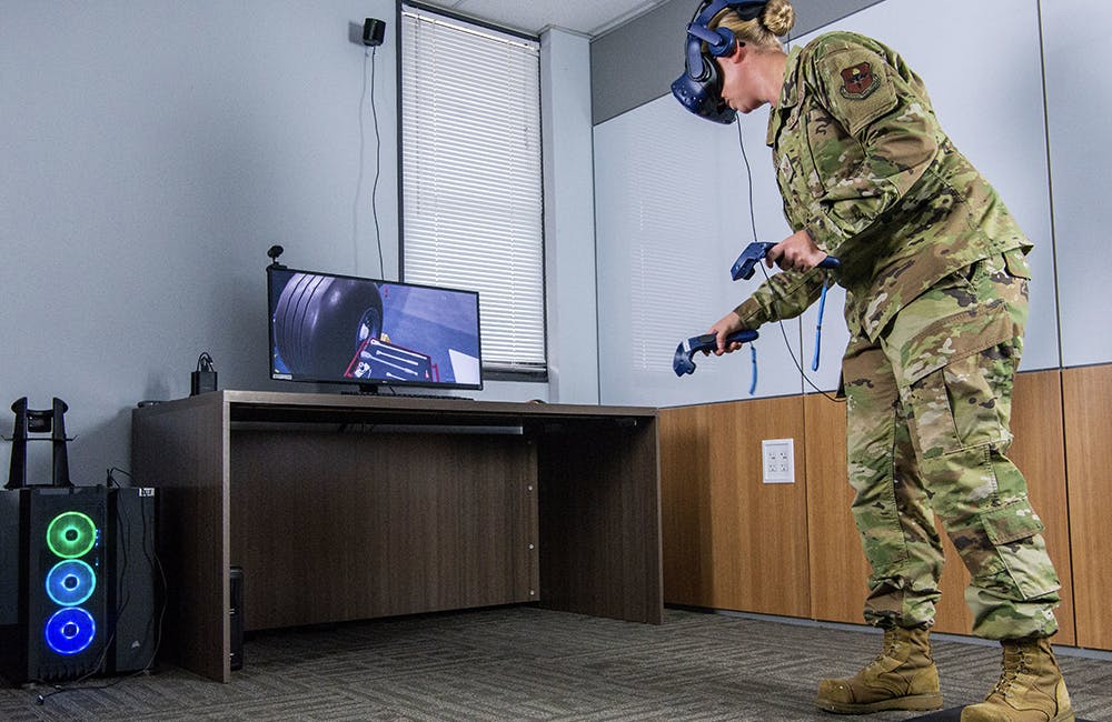 image of Air Force Staff Sgt. Renee Scherf, Detachment 23 curriculum engineer, MC-130H subject matter expert, demonstrates a virtual reality training system.