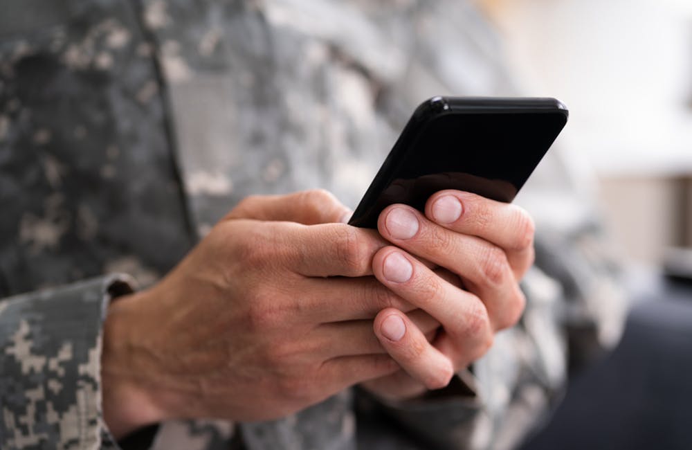 image of soldier holding smartphone
