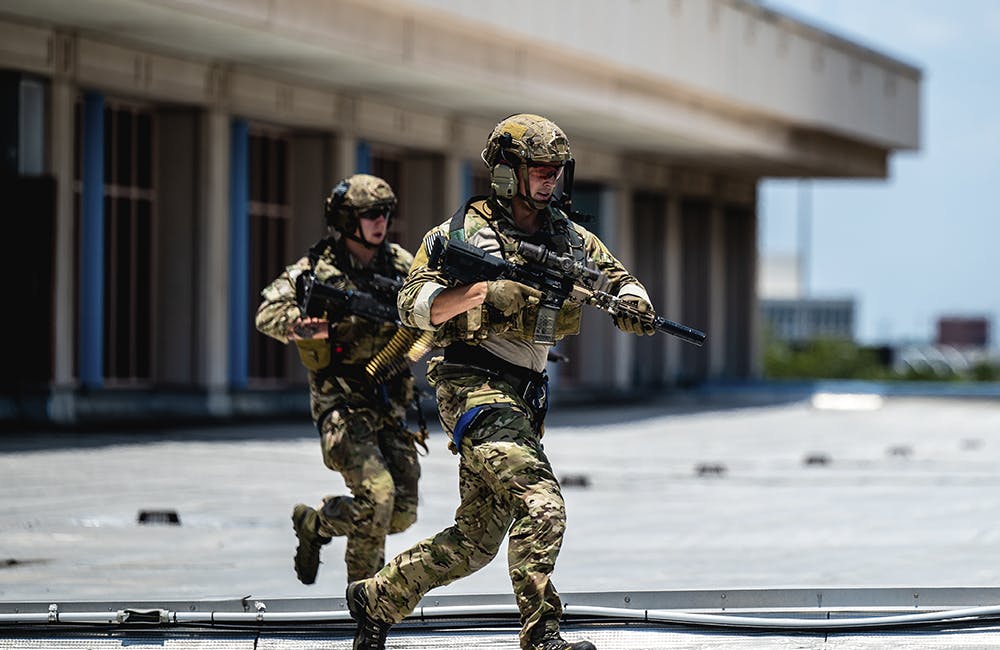 image of Two U.S. Special Operations Forces members sprint to their positions during a SOF capabilities demonstration May 18, 2022 in Tampa, Florida.