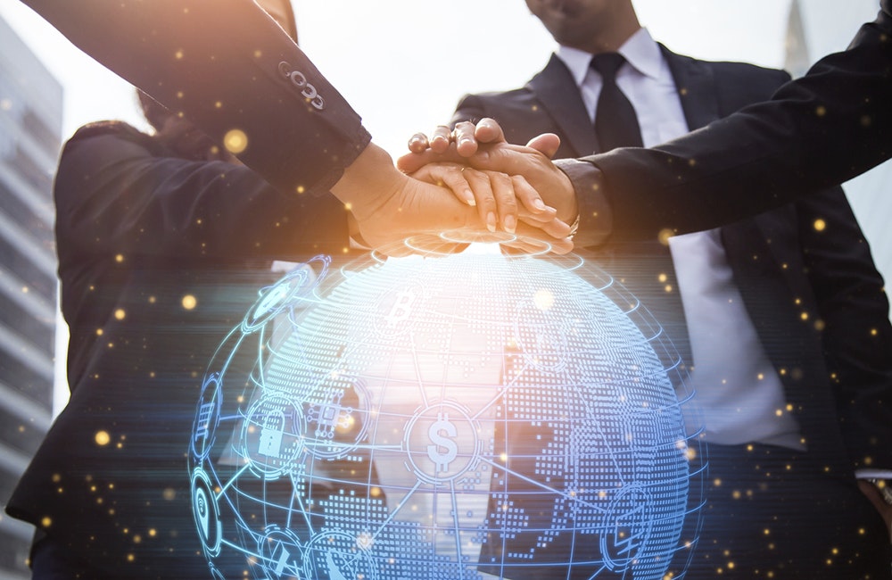 Close up of businessmen shaking hands. Global network and a world map in the foreground. block chain concept.