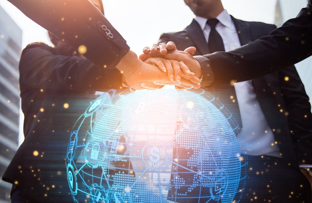 Close up of businessmen shaking hands. Global network and a world map in the foreground. block chain concept.