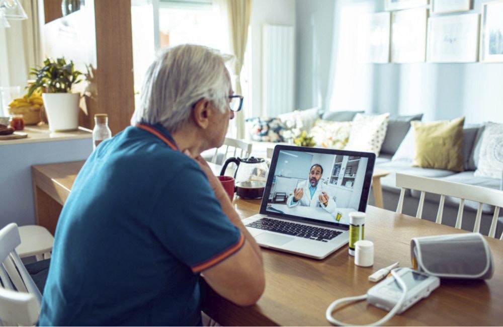 A man having a telehealth video call in his home with a doctor