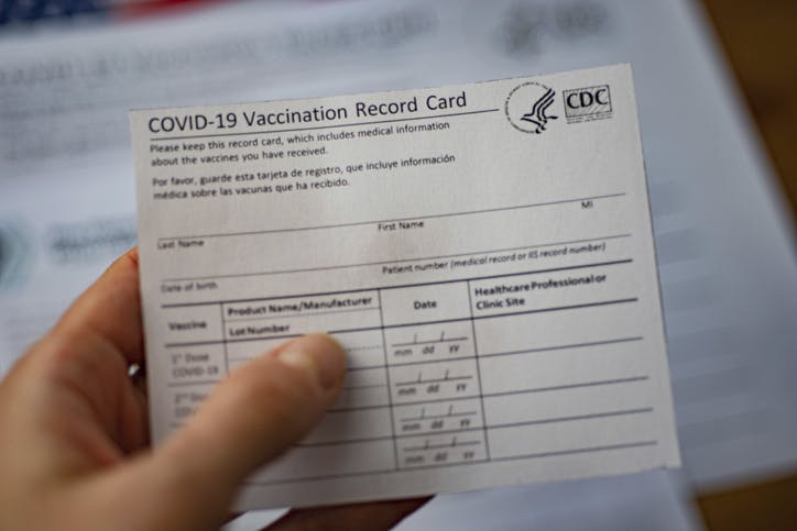 Washington, Dc, USA - December, 23,2020: Close up view of blurred COVID-19 Vaccination Record Card by CDC in hand.