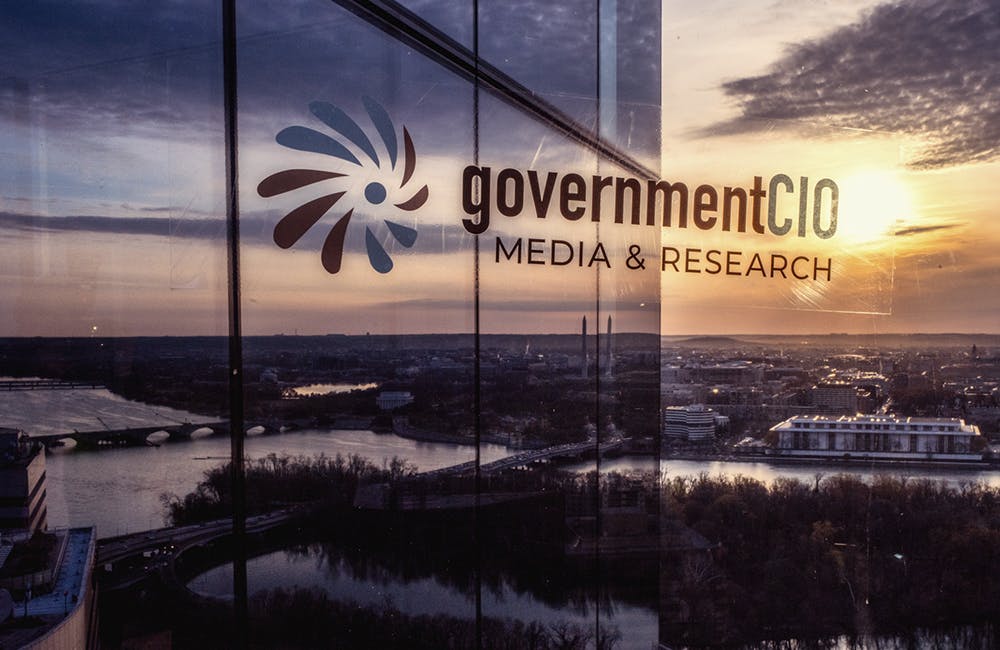Sunrise reflection on the building with event host GovernmentCIO Media & Research logo