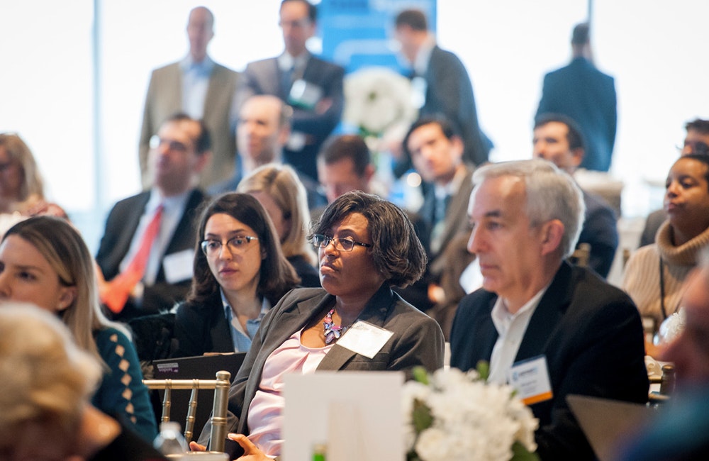 Audience members listening to a speaker.