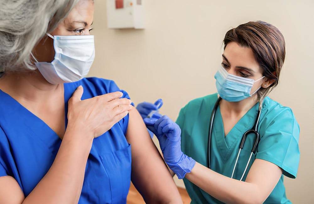 Image of Nurse administering vaccination to patient.