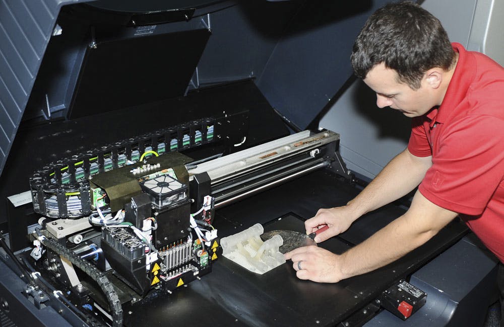 n engineer removes a 3D printed hydraulic manifold from the 3D printer July 24, 2014, at Joint Base McGuire-Dix-Lakehurst, N.J.