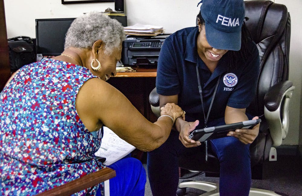FEMA Disaster Survivor Assistance team member Andrea Floyd helps a 79-year-old resident register for disaster assistance at the Disability Rights Center of the Virgin Islands after Hurricane Irma in 2017.