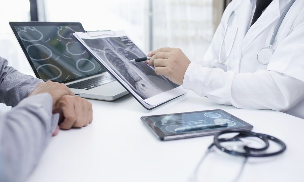 Clinicials look at a tablet screen