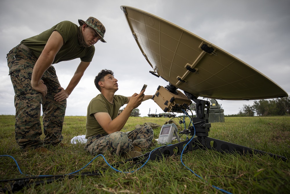 Two Marines prepare satellite equipment for a training exercise