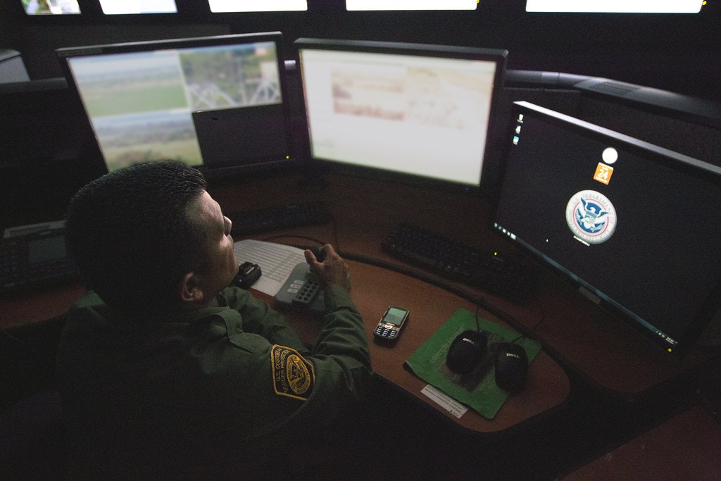 Border Patrol agent looks at a computer screen