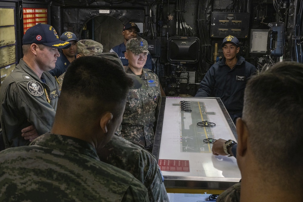 Military personnel tour a Navy ship