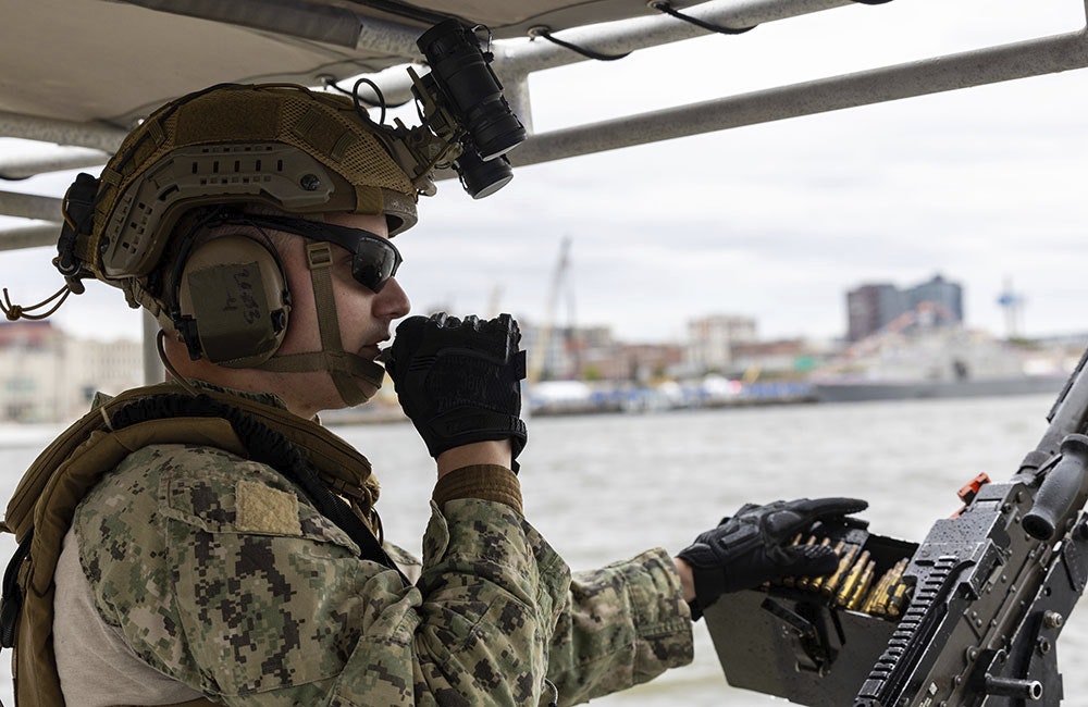 A U.S. Navy Explosive Ordnance Disposal Technician, assigned to Explosive Ordnance Disposal Group TWO, speaks on the radio during a live show demonstration on the Delaware River, Oct. 12, 2025.