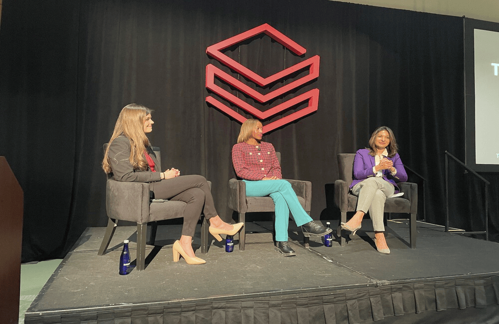 DOE Architecture, Engineering, Technology and Innovation Deputy CIO Bridget Carper (middle) speaks at Databricks’ Data and AI Summit in Washington, D.C., on Dec. 11, 2025.