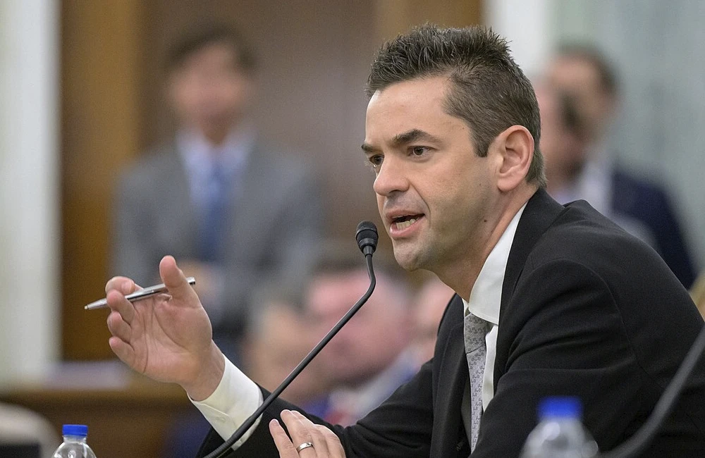 Man in a suit speaks into a microphone at Senate hearing.