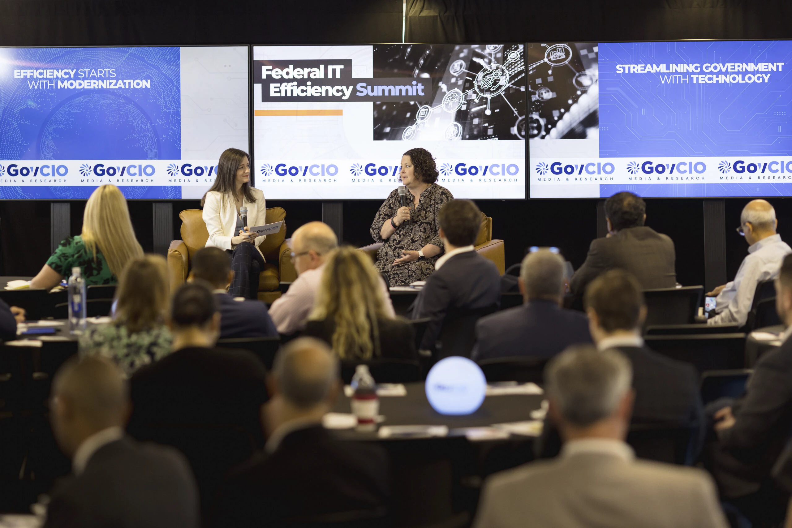 Speakers at an event in front of an audience