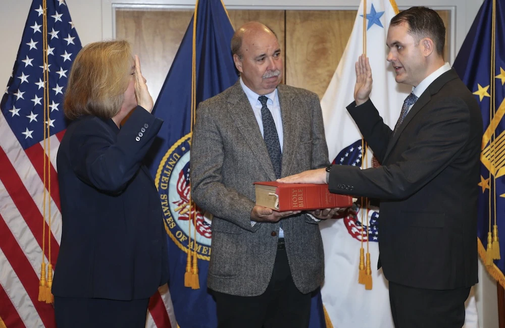 Three people stand during swearing in ceremony
