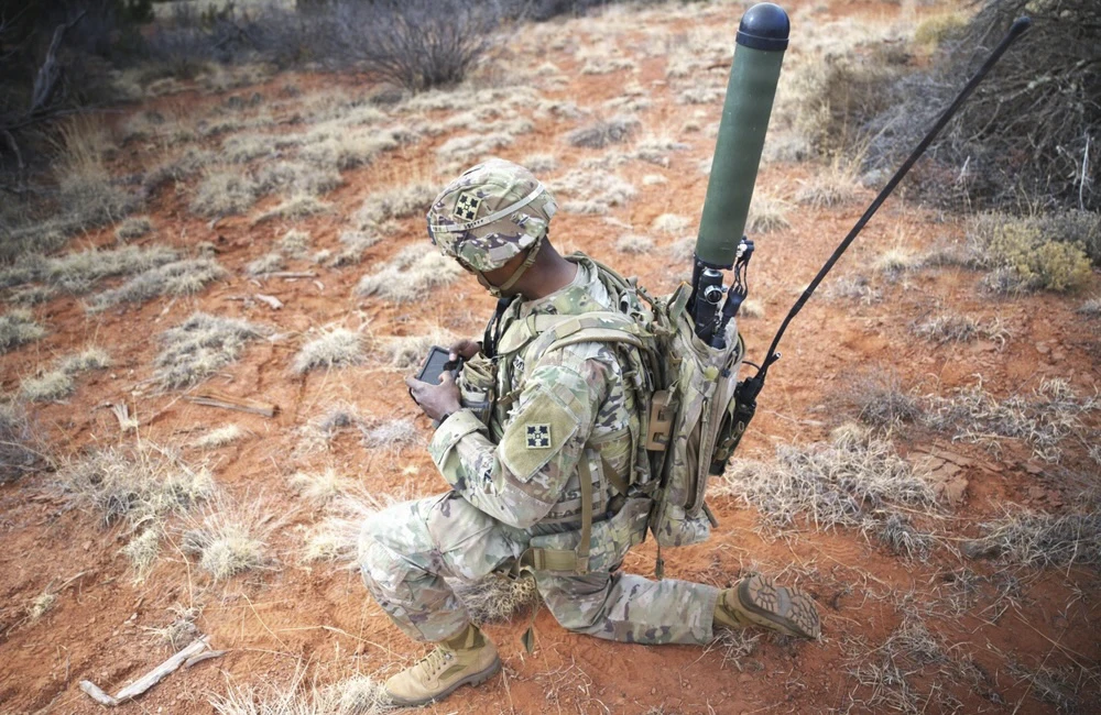 military servicemember operating equipment on a field